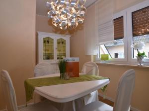 uma sala de jantar com uma mesa e cadeiras e um lustre em Wonderful apartment with barrel sauna em Stockheim