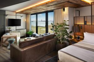 ein Hotelzimmer mit einem Sofa und einem Bett in der Unterkunft 1 Hotel Brooklyn Bridge in Brooklyn