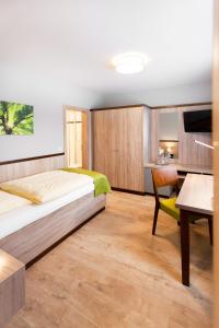 a bedroom with a bed and a desk and a table at Hotel Restaurant Lüdenbach in Overath