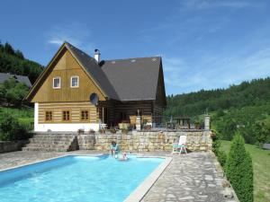 a house with a swimming pool in front of a house at villa with swimming pool in the hilly landscape in Pecka