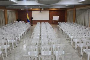 a room filled with white chairs and a whiteboard at Hotel Bogota Astral in Bogotá