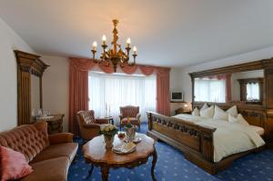 a bedroom with a large bed and a chandelier at Landhotel Lohmann in Langenfeld