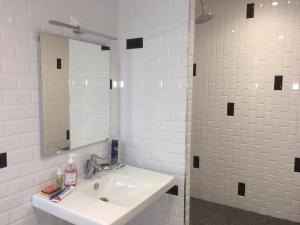 a white bathroom with a sink and a mirror at Le Petit Château des Cedres in Mouchamps