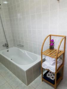 une salle de bain avec une baignoire et une étagère avec des serviettes dans l'établissement Apartment with beautiful ocean and city view, à Funchal 9 autres photos