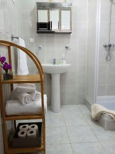 een badkamer met een wastafel, een spiegel en een douche bij Apartment with beautiful ocean and city view in Funchal
