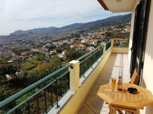 een balkon met een tafel en uitzicht op de stad bij Apartment with beautiful ocean and city view in Funchal