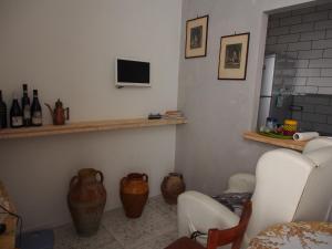 een woonkamer met 2 stoelen en een tv aan de muur bij I due Grappoli in Boscotrecase