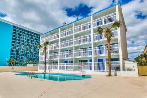 マートルビーチにあるBeachcomber Inn & Suitesのヤシの木が植わる白い大きな建物