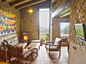 a living room with chairs and a couch and a tv at Can Nofre - Masia familiar en zona tranquila in Amer