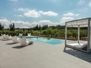 a pool with white lounge chairs and a gazebo at Belvilla by OYO Calet in Muro