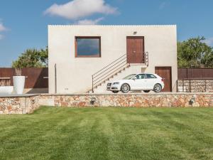 a white car parked in front of a house at Belvilla by OYO Calet in Muro