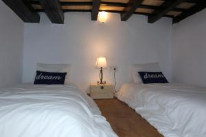 ベヘール・デ・ラ・フロンテーラにあるApartamentos Patio de la Juderiaのベッドルーム(白いベッド2台、ランプ付)