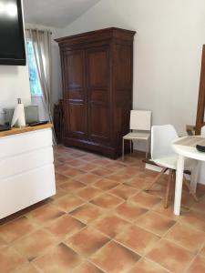 a living room with a wooden cabinet and a tiled floor at Maison d'hôtes Antoinette in Cogolin