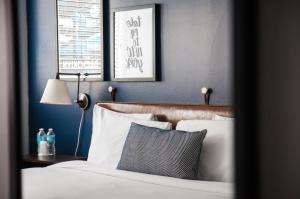 a bedroom with blue walls and a bed with white pillows at U Hotel Fifth Avenue I Empire State Building in New York