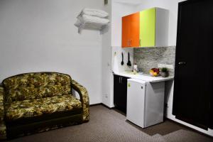 ズヴェニゴロドにあるSuponevo Studio Apartment Zvenigorodの椅子とシンク付きのキッチンが備わる客室です。