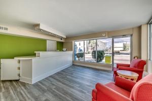 a lobby with two red chairs and a counter at Beachcomber Inn & Suites in Myrtle Beach