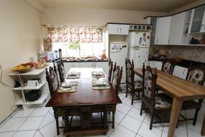 a kitchen with a table and chairs and a refrigerator at Pousada Kaluana in Urubici