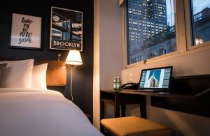 a hotel room with a bed and a desk with a laptop at U Hotel Fifth Avenue I Empire State Building in New York