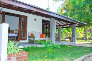 a patio of a house with a couch and a porch at Roseberry Cottage in Negombo