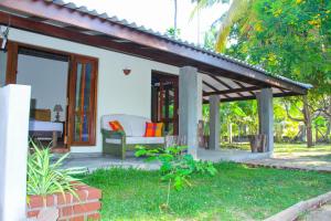 een patio van een huis met een bank en een veranda bij Roseberry Cottage in Negombo