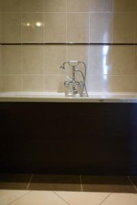 a bath tub with a faucet in a bathroom at Hostellerie du Coq d'Or in Jonzac