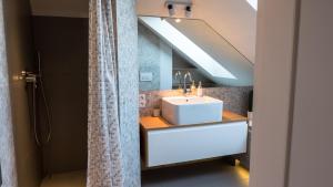 a bathroom with a sink and a shower at Apartament Jelitkowo in Gdańsk