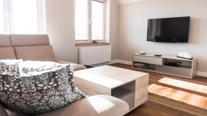 a living room with a couch and a flat screen tv at Apartament Jelitkowo in Gdańsk
