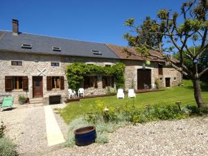 una antigua casa de piedra con sillas y un patio en Holiday home with large garden, en Dun-les-Places