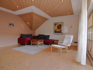 リーデンブルクにあるModern Holiday Home in Prunn near Lakeのリビングルーム(赤いソファ、テーブル付)