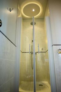 y baño con ducha y puerta de cristal. en Hostellerie du Coq d'Or, en Jonzac