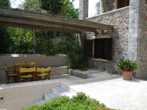 a patio with yellow chairs and a table and a building at Angelina Boutique Escape in Perdika