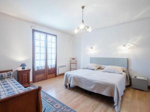 a white bedroom with two beds and a window at Cosy holiday home in Lantheuil with garden in Villefranche-du-Périgord