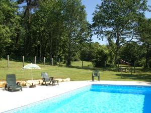 Saint-Cernin-de-lʼHermにあるPicturesque holiday home with poolのスイミングプール(椅子2脚、パラソル付)