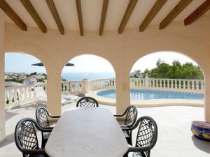 un patio con mesa y sillas y una piscina en Belvilla by OYO Magnolias, en Cumbre del Sol