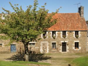 una vecchia casa in pietra con un albero di fronte di Charming holiday home in a green setting a Montaigu-les-Bois