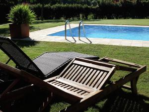 una mesa de picnic y 2 sillas junto a una piscina en Belvilla by OYO Casa Santiago de Compostela, en Roxos