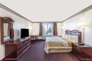 a hotel room with a bed and a television at Days Inn by Wyndham Evanston WY in Evanston