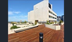 a large white building with a wooden deck at StayCentral - NGV Arts Centre Retreat Southbank in Melbourne