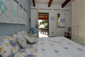 Un dormitorio con una cama blanca con almohadas azules y amarillas en B&B Nonno Stacca, en Stintino