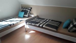 Dos camas en una habitación con almohadas azules y negras. en Seestraße, en Uhldingen-Mühlhofen 4 fotos más