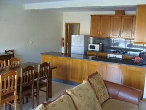 a kitchen with a couch and a table and a counter at Quinta do Grilo in Vieira do Minho