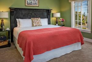 a bedroom with a large bed with a red blanket at Ravenscroft Inn in Port Townsend