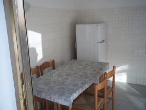a kitchen with a table and a refrigerator at Appartamento Gronda Lagunare in Tessera