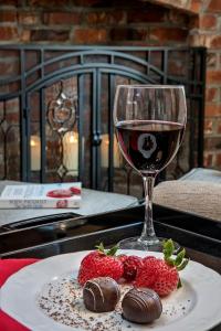 a glass of wine and strawberries on a table at Ravenscroft Inn in Port Townsend
