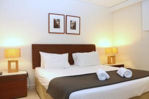 een slaapkamer met een groot bed met 2 lampen bij 422 Temple Beachside Penthouse in Palm Cove