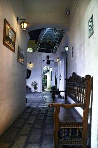 a hallway with a wooden bench in a building at La Compañía de Jerusalen in Arequipa