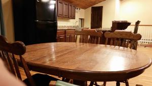 een keuken met een houten tafel en een zwarte koelkast bij Hansen House in Ontario