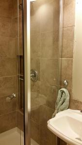 a shower with a glass door next to a sink at Hansen House in Ontario