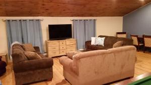 a living room with couches and a flat screen tv at Hansen House in Ontario