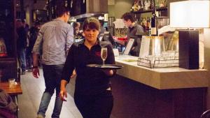 kobieta trzymająca talerz z kieliszkiem wina w obiekcie Criterion Hotel Sale w mieście Sale